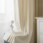 Rideau beige élégant pour décoration intérieure, idéal pour salon ou chambre, offrant une ambiance douce et apaisante. Statue décorative en arrière-plan ajoutant une touche artistique et sophistiquée à votre espace. Solution idéale pour embellir vos fenêtres avec style et modernité.