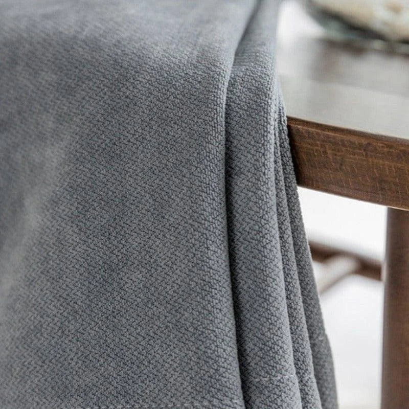 Couverture grise élégante sur table en bois, idéale pour décorer le salon ou la chambre, apportant une touche de confort et de style à votre intérieur. Accessoire intemporel pour un design moderne.