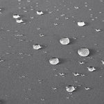 Gros plan sur une surface résistante à l'eau avec des gouttes en suspension, mettant en avant la technologie déperlante avancée pour une protection efficace contre l'humidité. Idéal pour les produits nécessitant une barrière contre les éléments extérieurs, assurant durabilité et performance.
