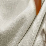 Textile beige avec texture subtile en relief, idéal pour décoration intérieure moderne et élégante. Parfait pour confectionner des rideaux ou recouvrir des meubles, ajoutant une touche de sophistication à tout espace.