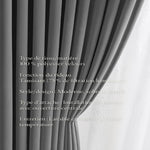 Gros plan sur un rideau en velours gris clair, plissé, installé devant une fenêtre avec un voilage blanc en arrière-plan.