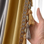 Main tenant un rideau décoratif avec franges et bordure détaillée, ajoutant une touche élégante à la décoration intérieure. Rehausse parfaitement l'esthétique des salons et chambres pour un style raffiné.