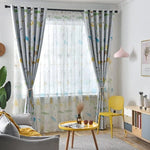 Chambre lumineuse avec grande fenêtre ornée de rideaux à motifs animaliers, entourée d'un décor moderne. La pièce comprend un canapé gris, une table d'appoint jaune et un abat-jour rose. Atmosphère chaleureuse et conviviale idéale pour un salon moderne.