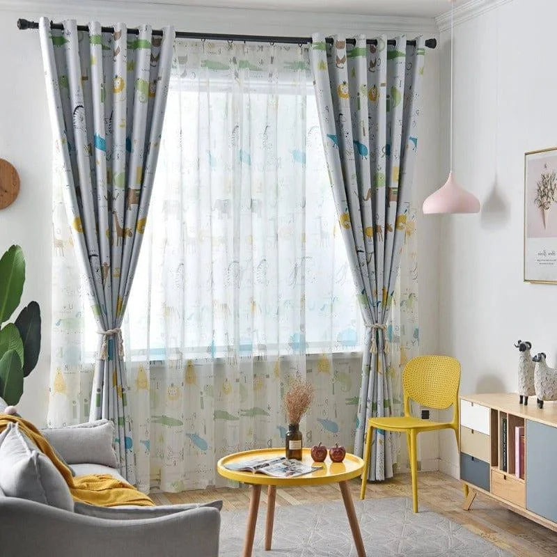 Chambre lumineuse avec grande fenêtre ornée de rideaux à motifs animaliers, entourée d'un décor moderne. La pièce comprend un canapé gris, une table d'appoint jaune et un abat-jour rose. Atmosphère chaleureuse et conviviale idéale pour un salon moderne.