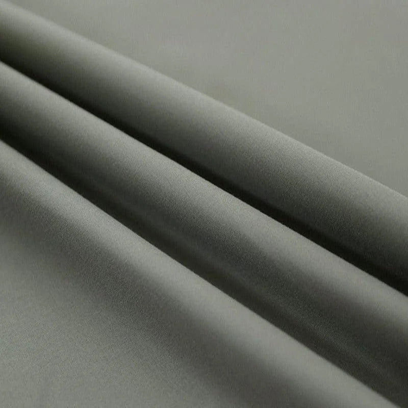 Image d'un tissu gris plié, idéal pour la confection de vêtements élégants et modernes. Ce textile est parfait pour créer des looks intemporels et s'adapter à diverses occasions. Son ton neutre facilement intégrable à toute garde-robe apportera une touche de sophistication discrète.