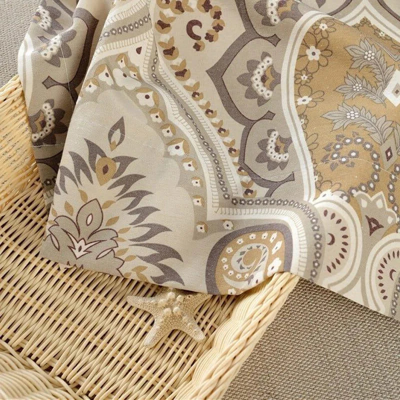 Tissu décoratif aux motifs paisley en tons beige et brun, délicatement posé sur un panier en osier, parfait pour apporter une touche élégante et chaleureuse à votre intérieur. Ce design raffiné s'intègre harmonieusement dans une décoration naturelle et apaisante.