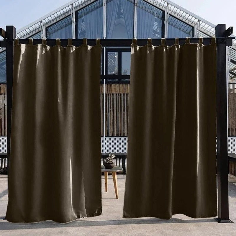 Rideaux extérieurs élégants de couleur sombre suspendus sur une terrasse moderne, offrant une solution d’intimité et de protection solaire pour les espaces extérieurs. Idéal pour créer une ambiance chaleureuse et contemporaine dans votre jardin ou patio. Profitez de moments de détente à l’abri du soleil direct tout en ajoutant une touche d’élégance à votre espace extérieur.