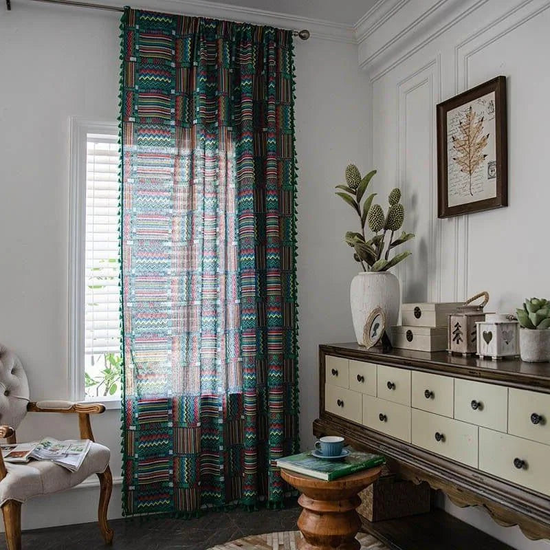 Rideau design bohème aux motifs géométriques colorés, intégré dans un salon moderne et élégant. Ce rideau apporte une touche artistique à la décoration intérieure, complétant un mobilier chic et des éléments décoratifs tendance. Idéal pour ceux cherchant à ajouter du caractère et de la chaleur à leur espace de vie.