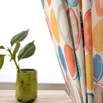 Rideaux colorés à motifs circulaires pour décoration intérieure moderne. Idéal pour ajouter une touche de couleur et de style à n'importe quelle pièce. Accompagné d'une plante verte en pot, parfaite pour harmoniser l'ambiance naturelle et chaleureuse de votre espace de vie. Simple à installer et parfait pour personnaliser votre décoration intérieure.