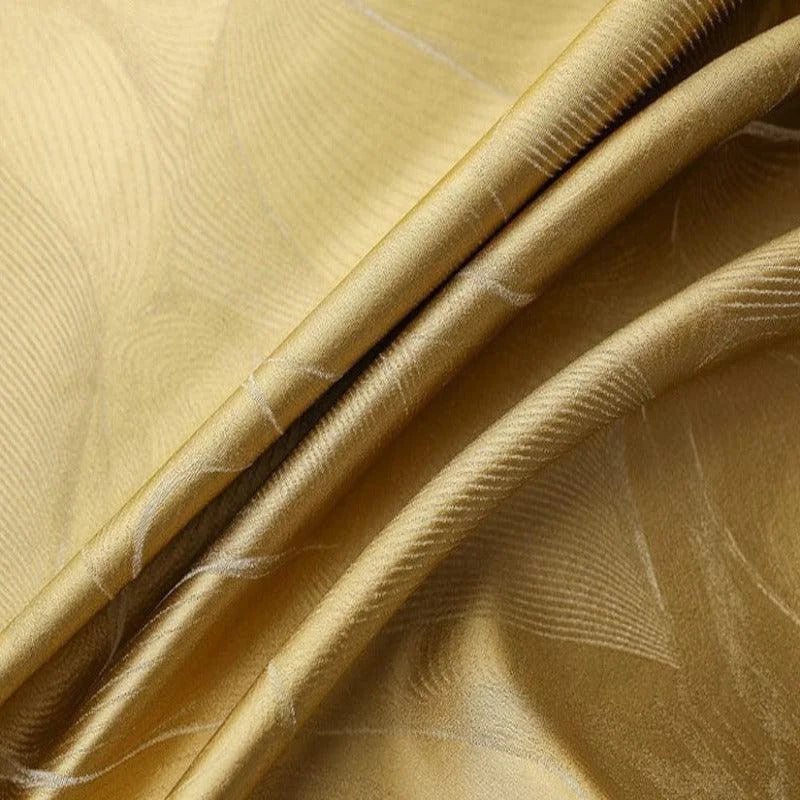 Drapé élégant en teinte dorée avec motifs subtils démontrant une finition luxueuse, idéal pour la décoration intérieure ou la confection de vêtements raffinés.
