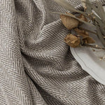 Texture élégante d'un tissu à motifs chevrons gris, idéal pour l'ameublement ou la décoration intérieure. Ce design raffiné et intemporel apportera une touche de sophistication à n'importe quel espace. Accessoirisé avec des fleurs séchées, il évoque une ambiance naturelle et apaisante.
