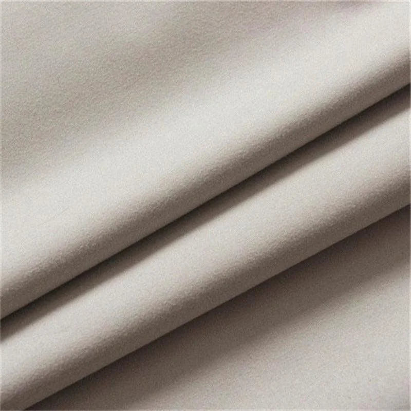 Tissu beige plié en plusieurs couches, idéal pour la confection de vêtements ou articles de décoration intérieure. Texture douce et élégante convenant à divers projets de couture.