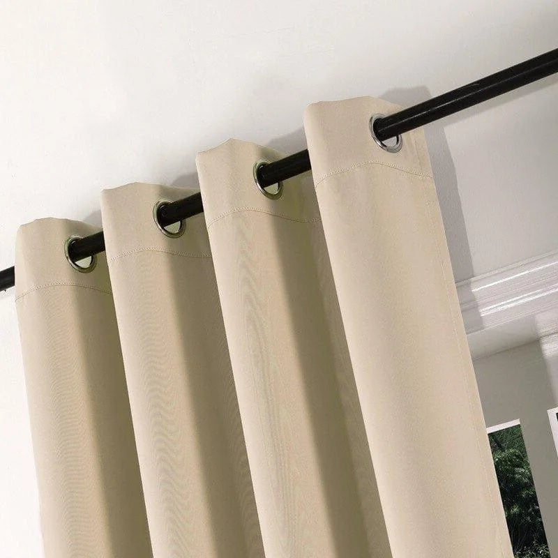 Rideau beige à œillets suspendu à une tringle noire, idéal pour un salon moderne. Propose une solution élégante et fonctionnelle pour filtrer la lumière et préserver l'intimité. Accessoire déco parfait pour embellir vos fenêtres et harmoniser votre intérieur.