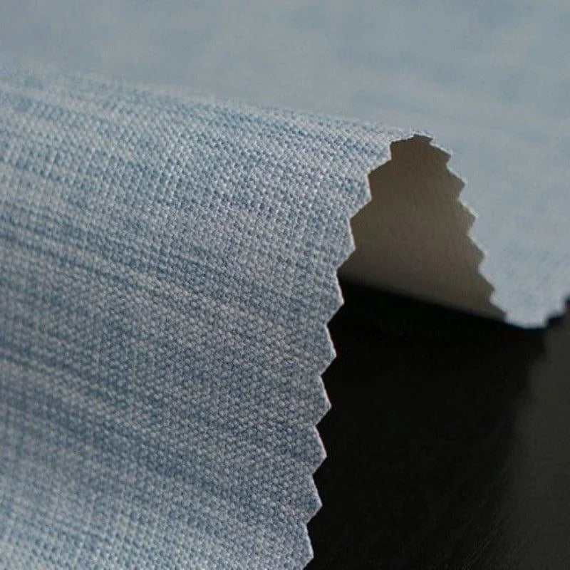 Tissu bleu en gros plan avec bordure dentelée, idéal pour la confection d'articles de mode ou de décoration intérieure. Les détails du tissage apportent une texture unique, mettant en valeur un design élégant et moderne. Parfait pour ajouter une touche de couleur subtile à tout projet créatif.