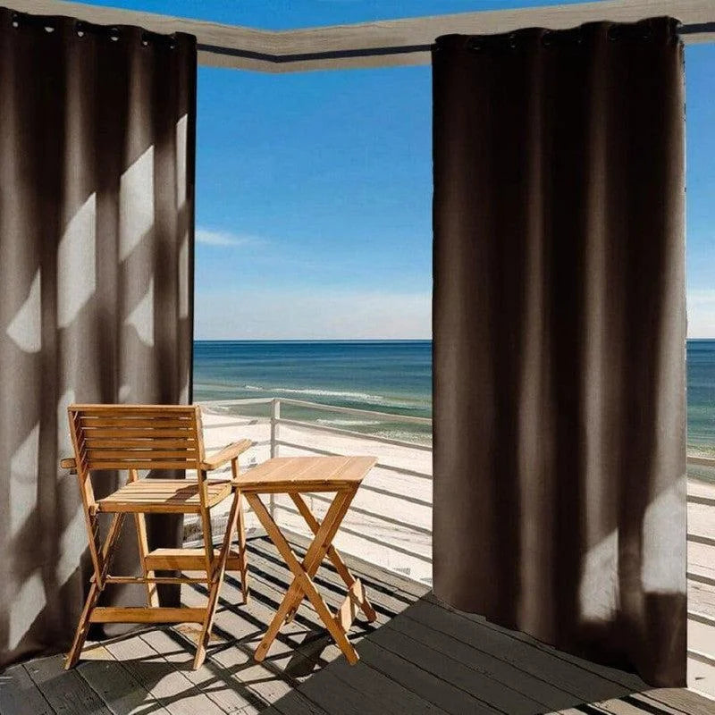 Rideau extérieur élégant pour terrasse avec vue sur la mer, accompagné d'un ensemble de mobilier de jardin en bois repliable, créant un espace détente idéal pour profiter de l'air frais et des paysages marins.