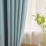 Rideaux bleu clair dans un salon moderne, apportant une touche élégante et apaisante à la décoration intérieure. Accessoire idéal pour filtrer la lumière tout en créant une ambiance chaleureuse.