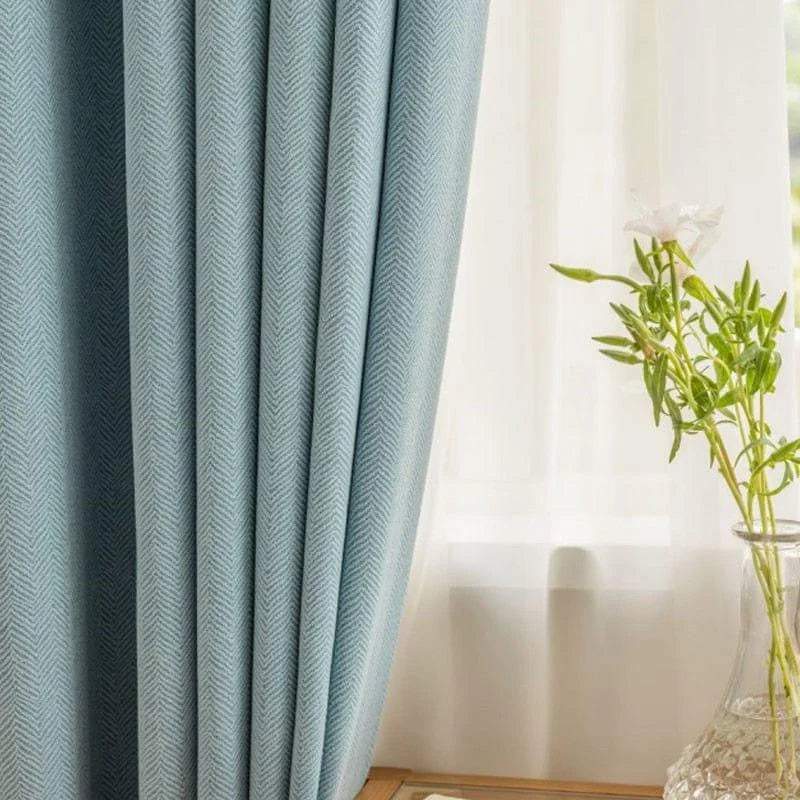 Rideaux bleu clair dans un salon moderne, apportant une touche élégante et apaisante à la décoration intérieure. Accessoire idéal pour filtrer la lumière tout en créant une ambiance chaleureuse.