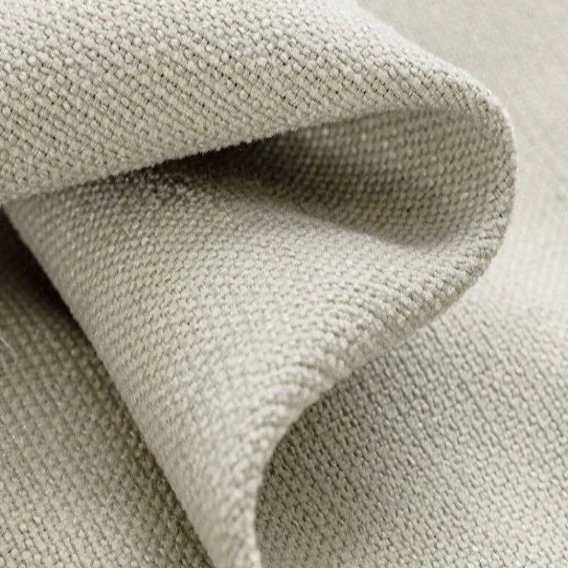 Gros plan sur une étoffe beige avec une texture tissée. Cette image montre les détails fins et l'élégance d'un tissu idéal pour la décoration intérieure ou la confection de rideaux. Le coloris neutre s'harmonise parfaitement avec divers styles de décoration.