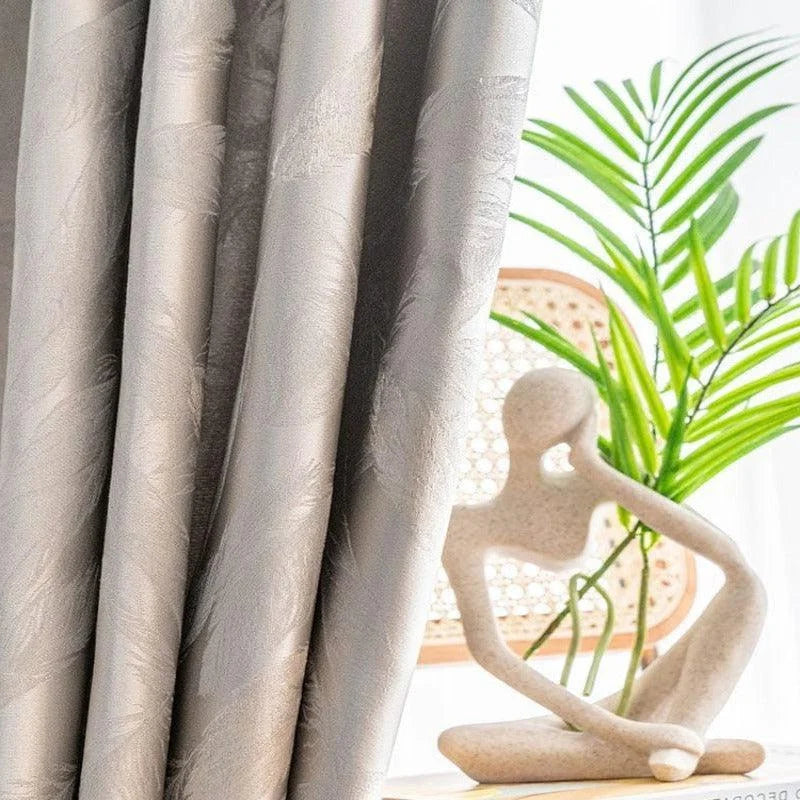 Rideaux élégants de couleur neutre, parfaits pour ajouter une touche moderne et raffinée à votre intérieur. Ils sont mis en valeur par une lumière naturelle douce, accompagnés d'une plante verte pour une ambiance zen et apaisante.