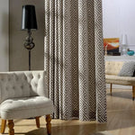 Rideau élégant à motif géométrique dans un salon moderne avec fauteuil design et lampe sur pied. Idéal pour créer une ambiance contemporaine et chaleureuse dans votre intérieur.