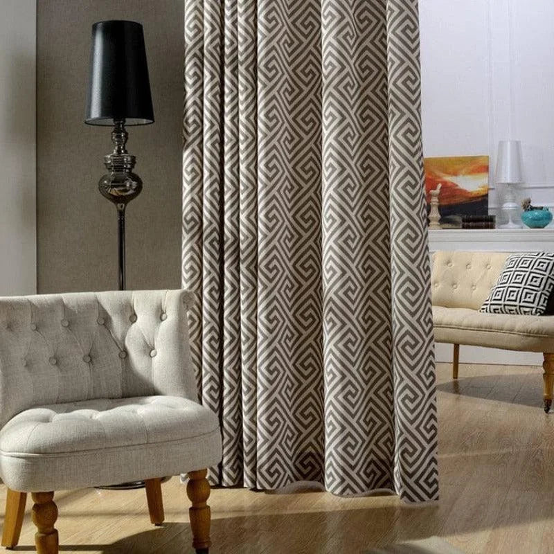 Rideau élégant à motif géométrique dans un salon moderne avec fauteuil design et lampe sur pied. Idéal pour créer une ambiance contemporaine et chaleureuse dans votre intérieur.
