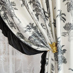 Rideau élégant avec motif tropical en noir et blanc, orné d'un embrasse dorée en forme d'ange, ajoutant une touche sophistiquée et exotique à votre intérieur. Idéal pour embellir votre salon ou chambre avec un style raffiné et unique.
