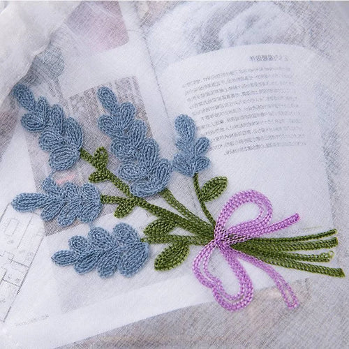 Broderie délicate représentant un bouquet de lavande avec un nœud décoratif rose, idéale pour embellir des articles textiles. Parfaite pour l'artisanat, la décoration intérieure ou la customisation de vêtements, cette broderie ajoute une touche élégante et champêtre avec ses détails minutieux et son allure naturelle.