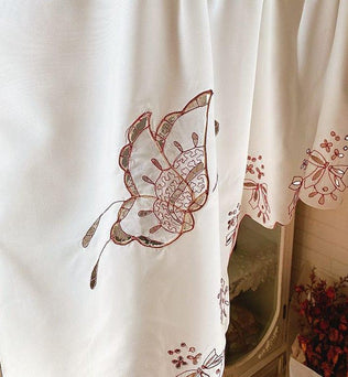 Rideau blanc brodé de motifs floraux détaillés, parfait pour ajouter une touche élégante et raffinée à votre décoration intérieure. Ce textile délicat transforme la lumière douce en un jeu de motifs captivant. Idéal pour les salons et chambres à coucher.