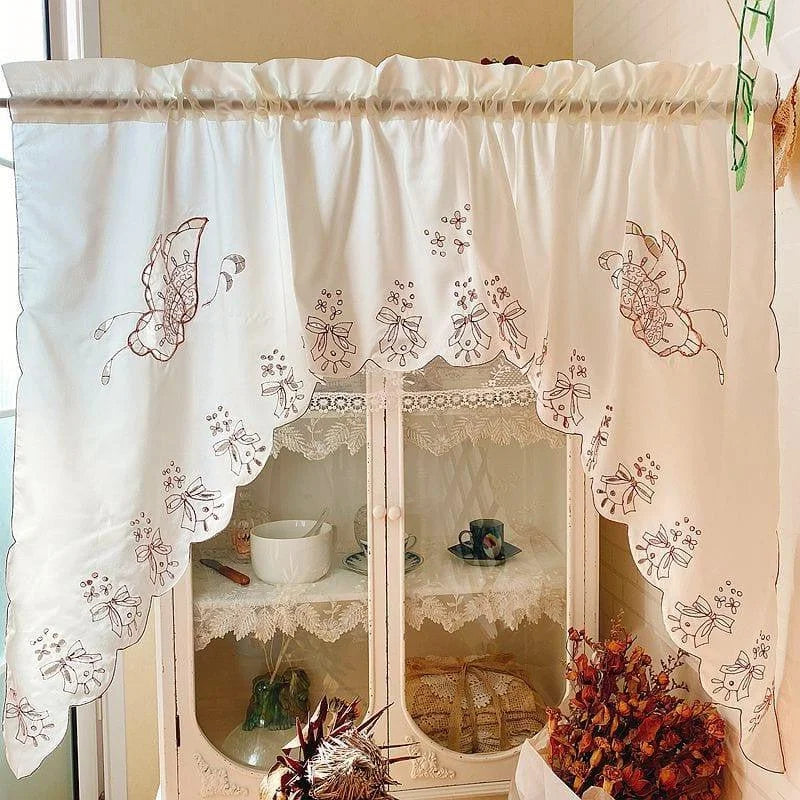 Rideau de cuisine élégant avec broderies florales et bordure festonnée, idéal pour ajouter une touche de charme classique à votre décoration intérieure. Parfait pour embellir vos fenêtres tout en offrant une ambiance chaleureuse et accueillante.
