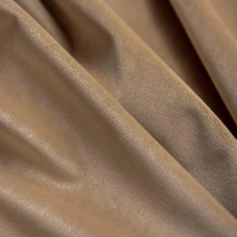 Texture de tissu marron avec plis doux, idéale pour la confection de vêtements élégants et confortables. Le tissu présente une finition lisse et un aspect luxueux, parfait pour des créations vestimentaires raffinées.