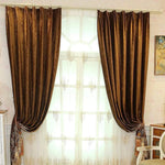 Rideaux élégants de couleur marron encadrant une grande fenêtre lumineuse, ajoutant une touche de sophistication à la pièce. Parfaits pour une décoration intérieure chaleureuse et accueillante. Motifs délicats visibles sur les voilages pour un contraste subtil et raffiné. Adaptés aux salons modernes et classiques. Idéal pour tamiser la lumière tout en préservant l'intimité. Accessoire décoratif essentiel pour une ambiance cosy et chic.