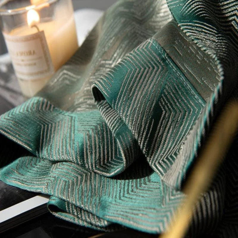 Tissu décoratif vert avec motifs géométriques élégant pour intérieur moderne, ambiance chaleureuse avec bougie allumée à côté, parfait pour rideaux ou décoration maison. Idéal pour créer une atmosphère raffinée dans chaque pièce.