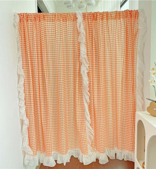 Rideaux décoratifs à carreaux orange avec volants blancs, parfaits pour ajouter une touche champêtre et lumineuse à votre intérieur. Ces rideaux élégants rehaussent le style de votre salon ou chambre, en apportant chaleur et charme. Accessoire idéal pour les décors modernes et rétro.
