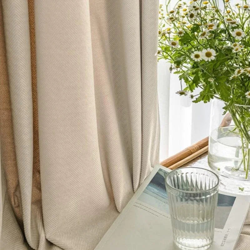 Rideaux élégants dans un intérieur lumineux, accompagnés d'un vase de fleurs blanches et d'un verre d'eau sur une table, créant une atmosphère apaisante et accueillante. Idéal pour ajouter une touche de raffinement et de fraîcheur à votre décoration d'intérieur.