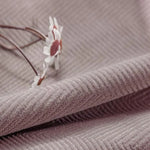 Tissu d'ameublement rose texturé avec motif chevron, parfait pour la décoration intérieure élégante. Fleur blanche ajoutant une touche délicate et naturelle. Idéal pour créations originales et modernes.