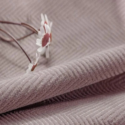 Tissu d'ameublement rose texturé avec motif chevron, parfait pour la décoration intérieure élégante. Fleur blanche ajoutant une touche délicate et naturelle. Idéal pour créations originales et modernes.