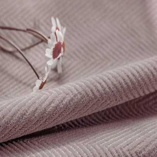 Tissu d'ameublement rose texturé avec motif chevron, parfait pour la décoration intérieure élégante. Fleur blanche ajoutant une touche délicate et naturelle. Idéal pour créations originales et modernes.