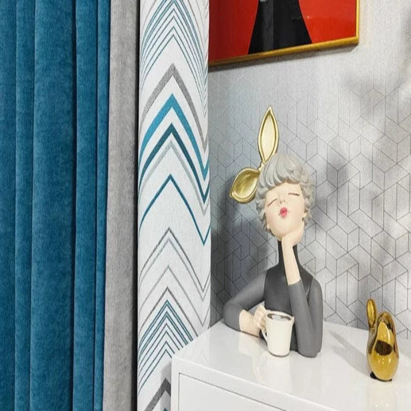Décoration d'intérieur moderne avec rideaux élégants en nuances de bleu et motifs géométriques. Une statuette artistique ajoute une touche de personnalité, tandis qu'un élément décoratif doré apporte une touche de luxe. Une parfaite harmonie pour un salon contemporain et chic.