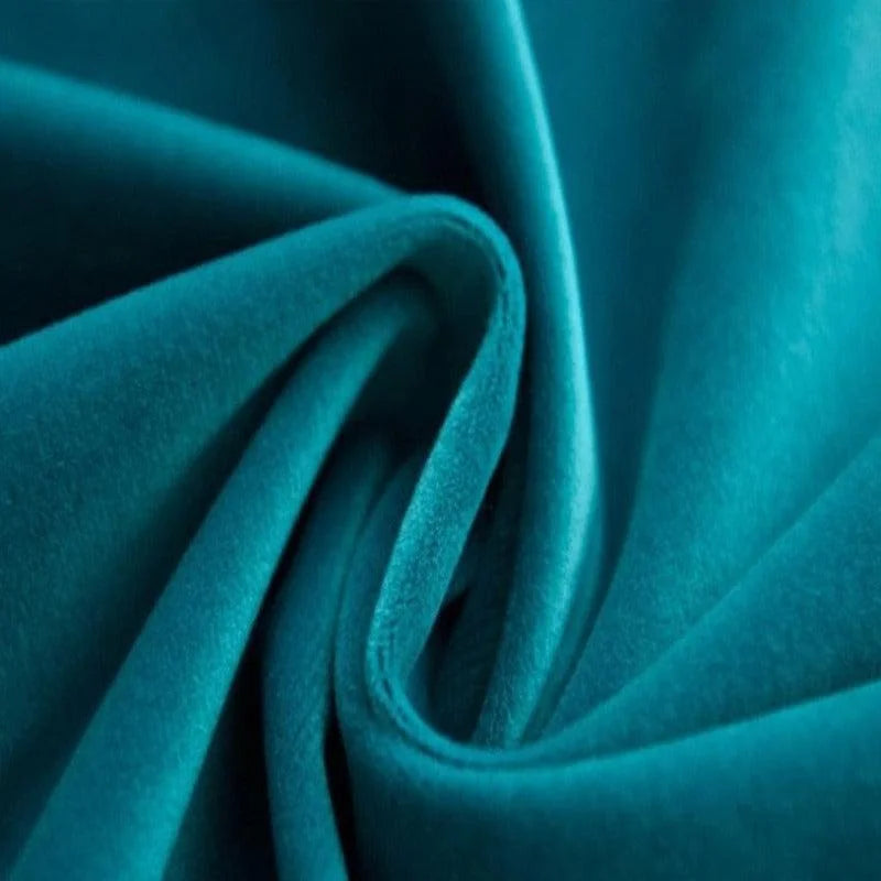 Tissu bleu turquoise plié en gros plan, mettant en valeur sa texture douce et élégante. Cette étoffe luxueuse est idéale pour la décoration intérieure, la confection de vêtements ou d'accessoires. Sa teinte vibrante ajoute une touche sophistiquée et moderne à différents projets créatifs.