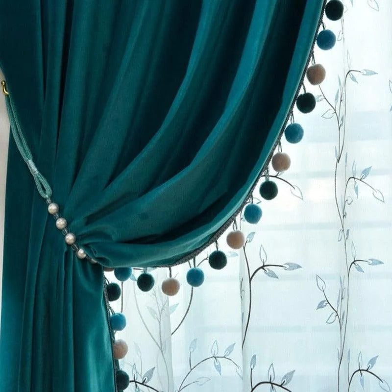 Rideau élégant turquoise avec pompons décoratifs, parfait pour ajouter une touche d'élégance à votre intérieur. Ce rideau s'associe harmonieusement à des voilages blancs ornés de motifs floraux pour un look raffiné. Idéal pour un salon ou une chambre, il crée une ambiance chaleureuse tout en offrant une belle filtration de la lumière.