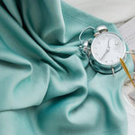 Réveil vintage argenté sur drap bleu pastel, alliant élégance et douceur pour une ambiance de chambre apaisante et stylée. Ajoutez une touche rétro à votre décoration intérieure.