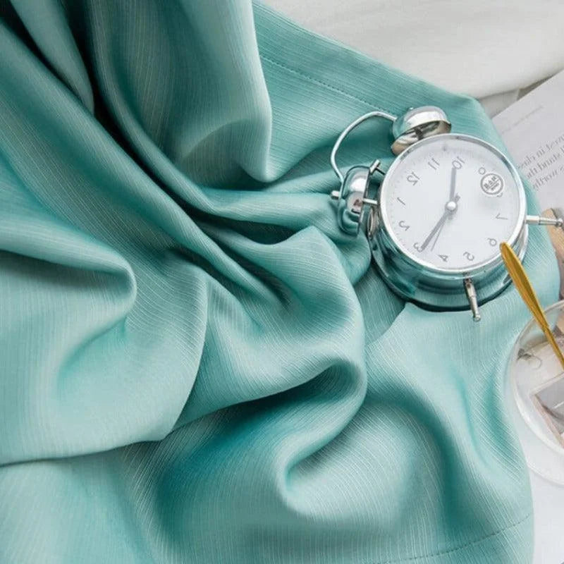 Réveil vintage argenté sur drap bleu pastel, alliant élégance et douceur pour une ambiance de chambre apaisante et stylée. Ajoutez une touche rétro à votre décoration intérieure.