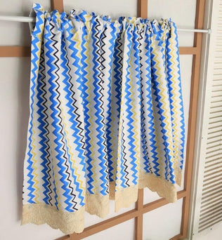 Rideau décoratif à motifs zigzag multicolores, idéal pour ajouter une touche moderne à votre intérieur. Ce modèle présente des tons de bleu, jaune et blanc, apportant fraîcheur et dynamisme à n'importe quelle pièce. Parfait pour le salon, la chambre ou la cuisine, ce rideau s'intègre facilement à divers styles décoratifs.