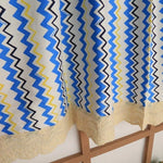 Rideau à motifs géométriques ondulés en bleu, jaune et noir avec bordure décorative en dentelle crème, idéal pour ajouter une touche moderne et colorée à votre intérieur. Parfait pour le salon ou la chambre, ce rideau design apporte style et élégance à votre décoration.