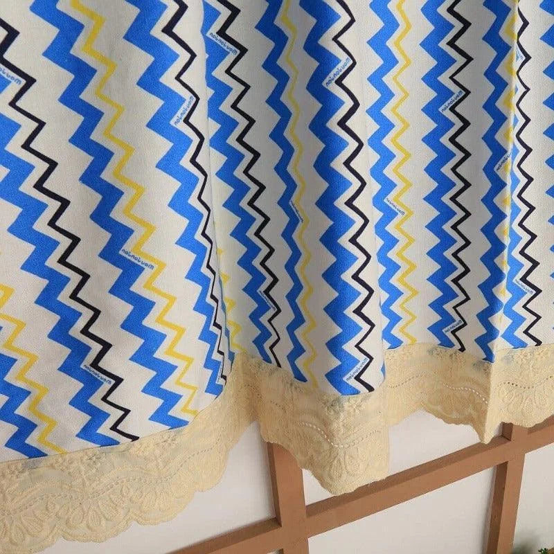 Rideau à motifs géométriques ondulés en bleu, jaune et noir avec bordure décorative en dentelle crème, idéal pour ajouter une touche moderne et colorée à votre intérieur. Parfait pour le salon ou la chambre, ce rideau design apporte style et élégance à votre décoration.