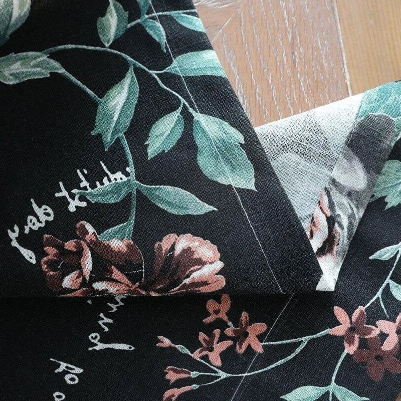 Motif floral élégant sur fond noir pour une décoration intérieure raffinée. Design botanique avec des fleurs et des feuillages verts, idéal pour ajouter une touche de nature et de sophistication à votre espace. Parfait pour les rideaux, nappes, et autres éléments décoratifs.
