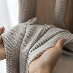 Rideau en tissu texturé, motif chevron gris et blanc, présenté en gros plan. Idéal pour ajouter une touche d'élégance et de modernité à votre intérieur. Fabriqué à partir de matériaux de haute qualité pour une durabilité et un style intemporel. Parfait pour le salon, la chambre ou tout autre espace de vie.