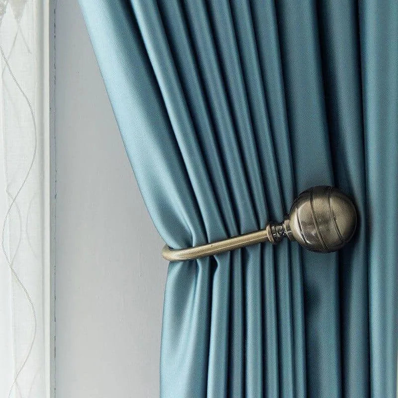 Rideau bleu élégant avec embrasse dorée, parfait pour ajouter une touche de sophistication à votre intérieur. Accessoire de décoration pour fenêtres, alliant style et praticité. Solution idéale pour contrôler la lumière dans votre pièce.