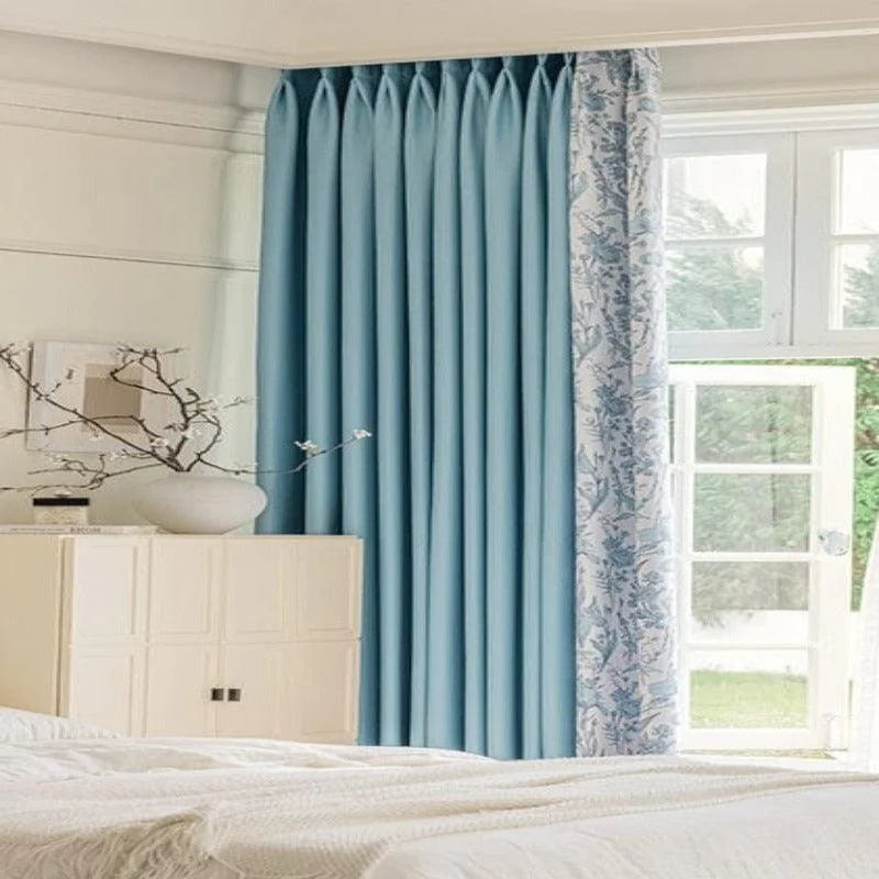 Rideaux élégants et contemporains pour chambre à coucher avec motifs floraux et teinte bleue, apportant une ambiance apaisante et lumineuse à votre intérieur. Transformez votre espace avec ce design chic, idéal pour la décoration de votre maison. Fenêtre ouverte laissant entrer la lumière naturelle, créant une atmosphère sereine et accueillante.