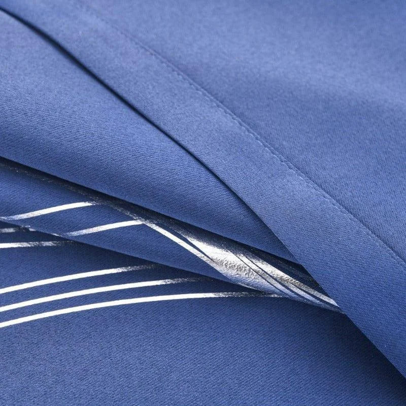 Tissu bleu avec motifs argentés, plié en plusieurs couches, idéal pour vêtements modernes et élégants, adapté à la confection de robes ou vestes tendance. Design intemporel pour un style sophistiqué et raffiné.